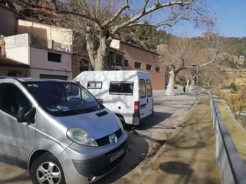 Two vans seen parked in front of the town of margalef