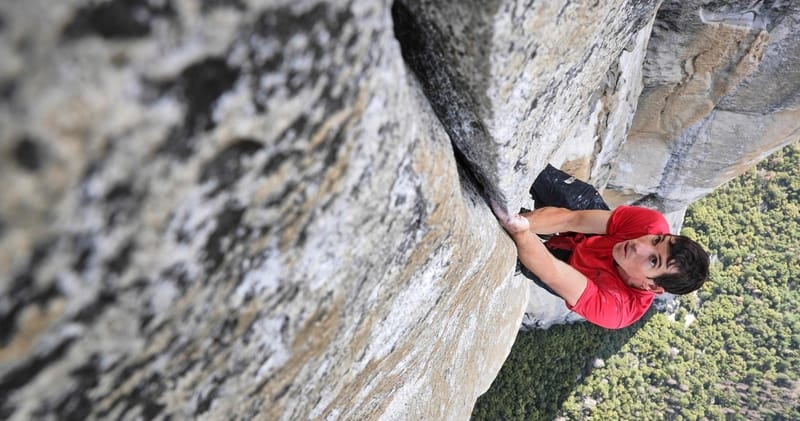 climber using hands to climb on grey rock