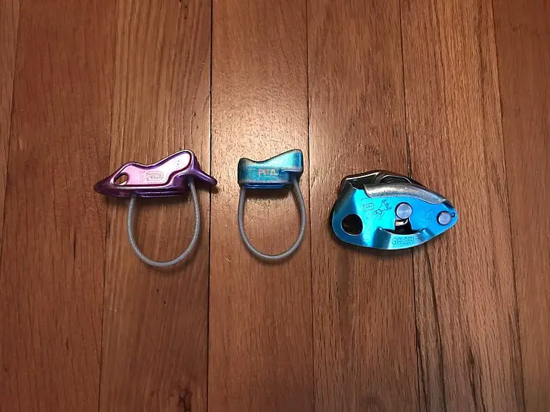 three different belay devices next to each other