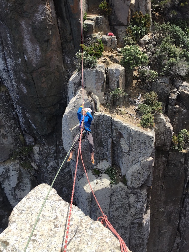 man doing totem pole tyrolean traverse in Tasmania Australia
