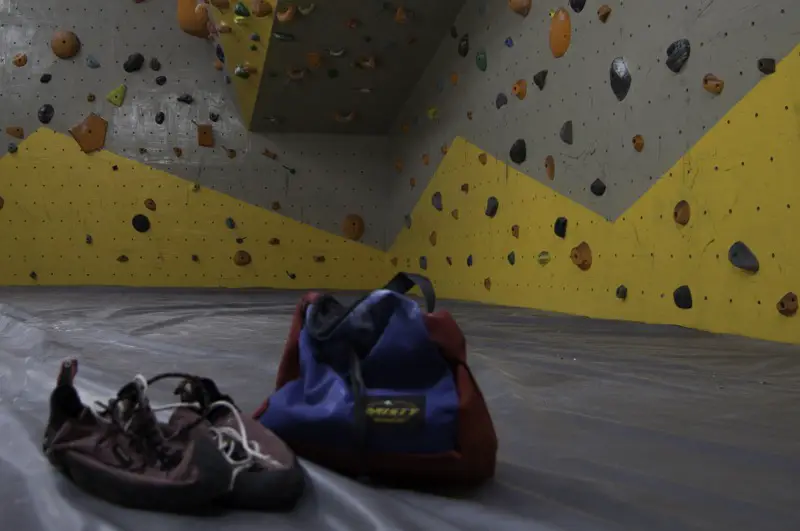 Bouldering shoes with chalk bucket in the gym
