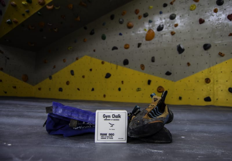 Climbing shoes in gym with brick of chalk in middle