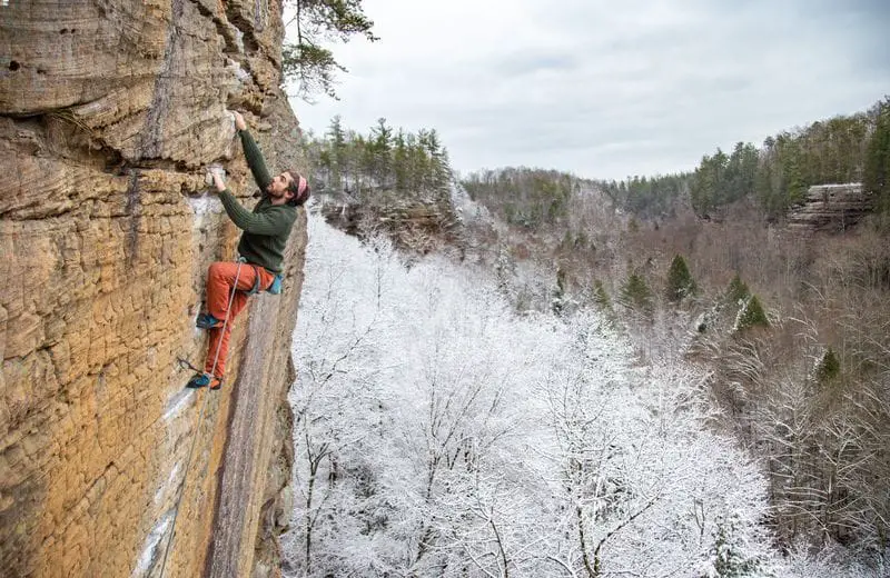 Man climbing at the Red with snowy trees in background 