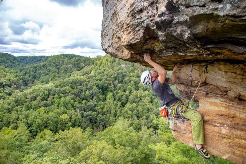 Epic photo of man trad climbing at the red river gorge about to climb roof