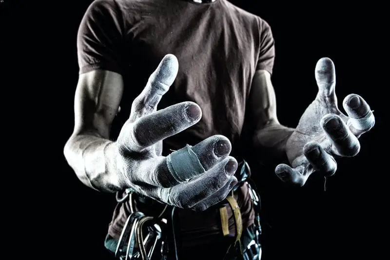 muscular male rock climber showing chalked hands