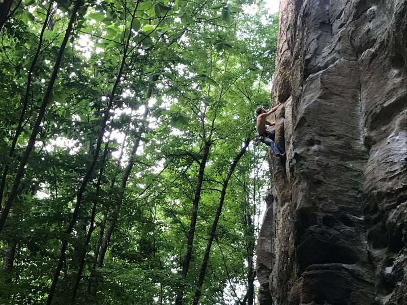 Man climbing rock in the forest 