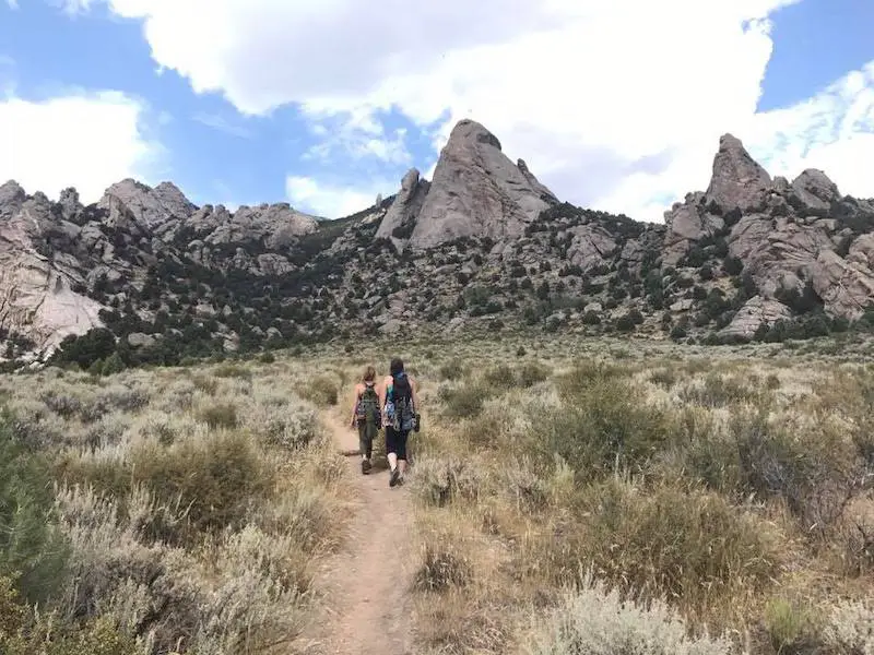 two female climbers walking towards rocky mountain