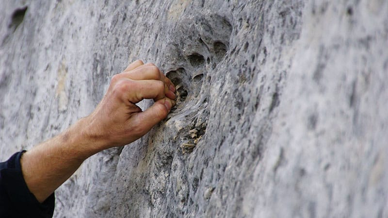 man climbing focus on hands and grip